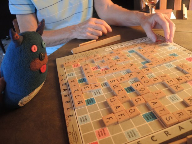 Edgar is looking at a scrabble board where the game is nearly over.  There are many words made on the board. 