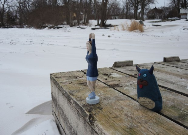 Edgar is standing back from the edge of a dock, keeping an eye on Sonya who is a figure skating figurine with her hands over her head, looking like she is ready to dive. 